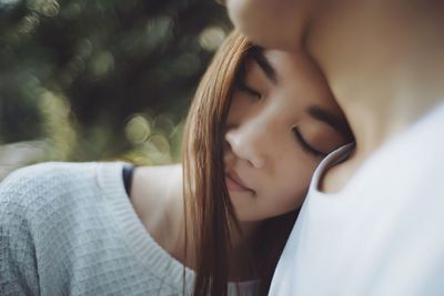 Young woman resting head on man shoulder