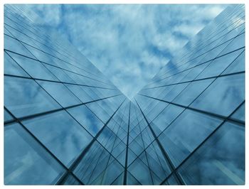 Low angle view of modern building against cloudy sky