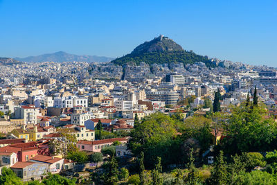 Aerial view of townscape against clear blue sky