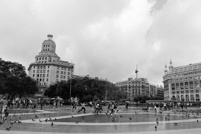 People in town square against sky