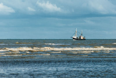 Fishing boat fishing at evening near the coast in autumn