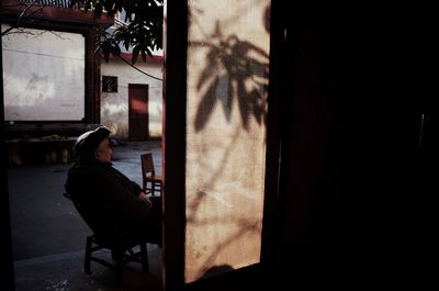 Side view of man sitting on chair