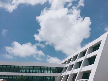 Low angle view of modern building against cloudy sky