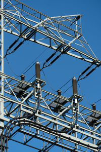 Low angle view of telephone pole against clear blue sky