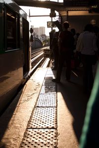 People at railroad station platform against sky