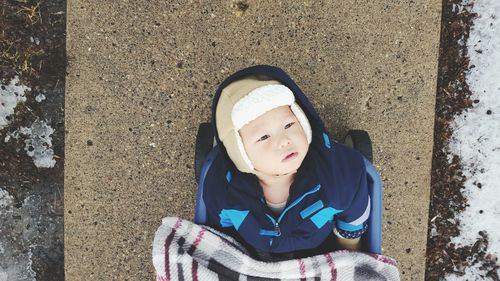 Directly above view of toddler in baby carriage on footpath