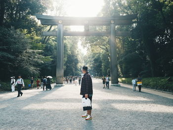 Rear view of people walking in forest