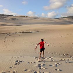 Rear view of man on sand dune