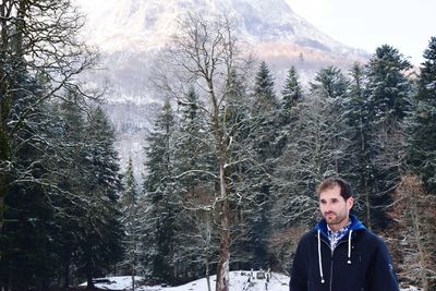 Portrait of young man in forest during winter