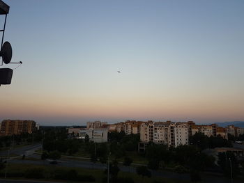 Buildings against clear sky at sunset