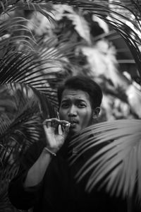 Portrait of young man smoking cigarette outdoors