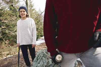 Full length of friends standing in park during winter