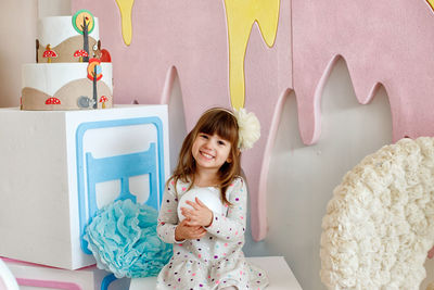 Portrait of smiling girl holding indoors at home