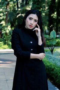 Portrait of beautiful young woman standing outdoors