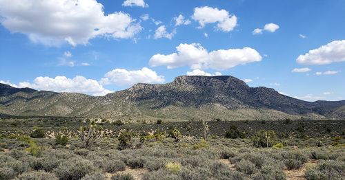 Scenic view of land and mountains against sky