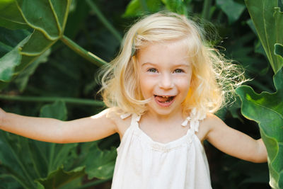 Portrait of little girl standing amidst plants