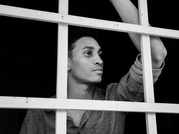 A young man looks through a window 