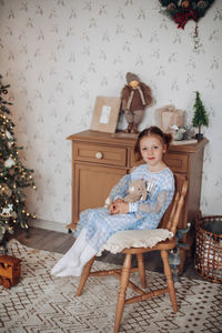 Young woman sitting on chair at home
