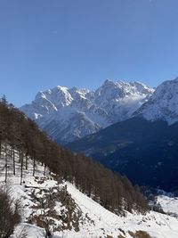 Scenic view of snowcapped mountains against clear blue sky