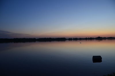 Scenic view of lake against clear sky during sunset