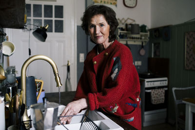 Senior woman doing chores in kitchen at home