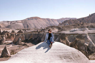 Rear view of woman standing on rock