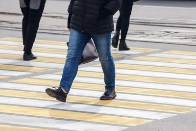 Low section of man walking on road