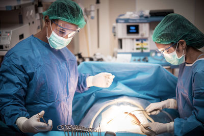 Surgeons performing operation on patient at hospital