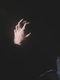 Close-up of hand over black background