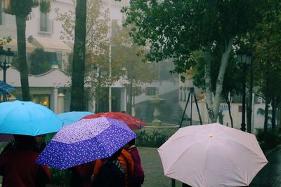 People walking on wet umbrella during rainy season