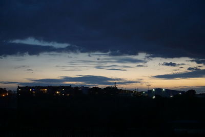 Silhouette of trees against cloudy sky