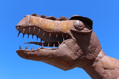 Low angle view of metal sculpture of dinosaur