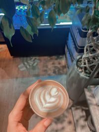 High angle view of hand holding coffee cup