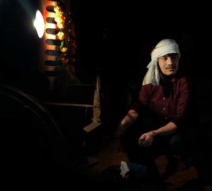 Full length of man sitting in illuminated temple