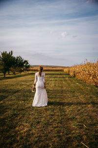 Rear view of woman with umbrella on field