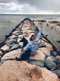 Woman gesturing peace sign at beach