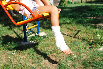 Low section of woman standing on grassy field