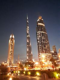 Low angle view of illuminated buildings against sky at night