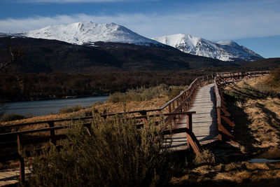 Jetty with lake against rocky landscape