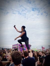 People at concert against cloudy sky