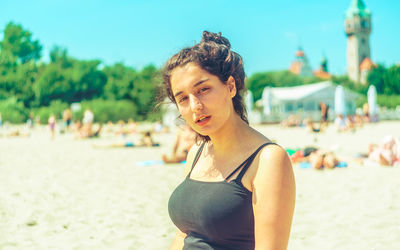 Beautiful young woman on beach against sky