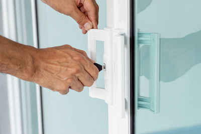 Cropped hand of man repairing door