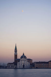 View of buildings against clear sky at sunset