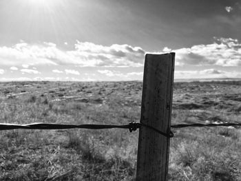 Wooden fence on field against sky