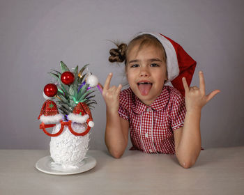 Happy cute little girl near the santa claus face made with pineapple