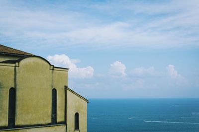 Building by sea against sky