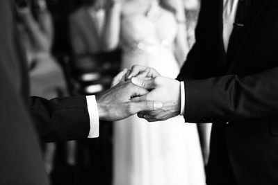 Gay couple holding hands during wedding ceremony