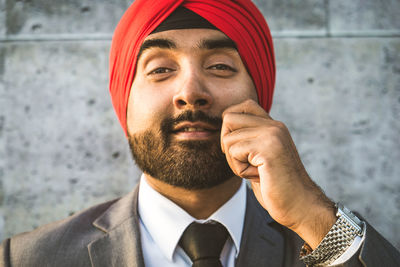 Close-up of businessman holding mustache while standing outdoors