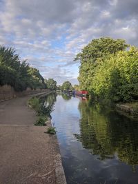 Scenic view of river by trees against sky