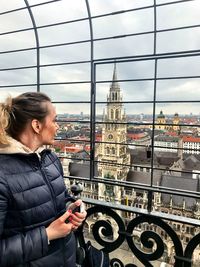 Woman looking at cityscape against sky